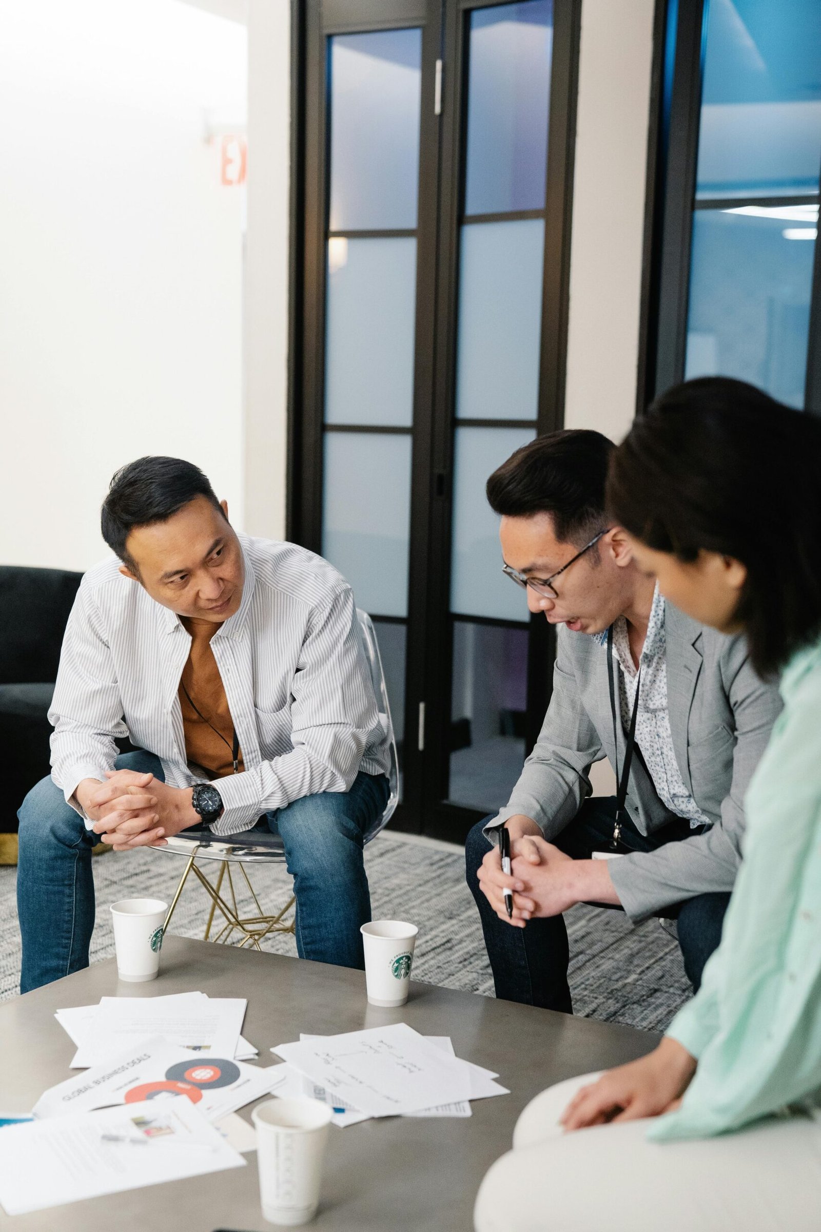 Three colleagues engage in a collaborative brainstorming session in a modern office.